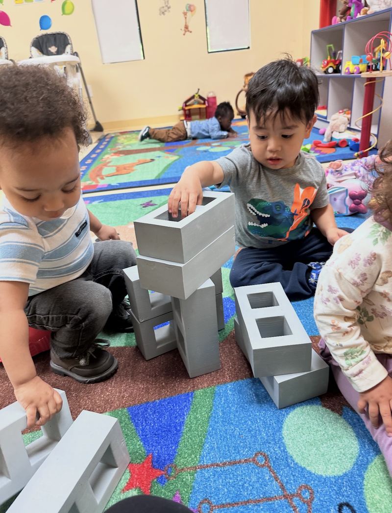 Toddlers building with big soft blocks.