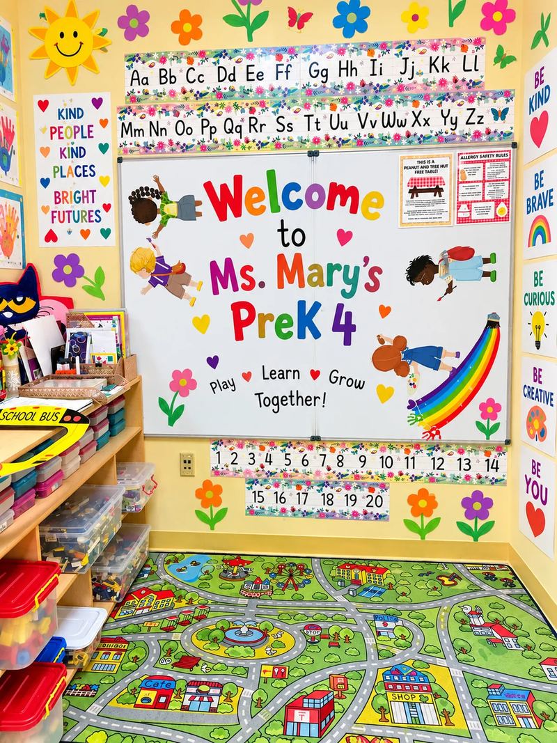 Ms. Mary's Pre-K 4 classroom with alphabet and number lines above the whiteboard and a city road play rug