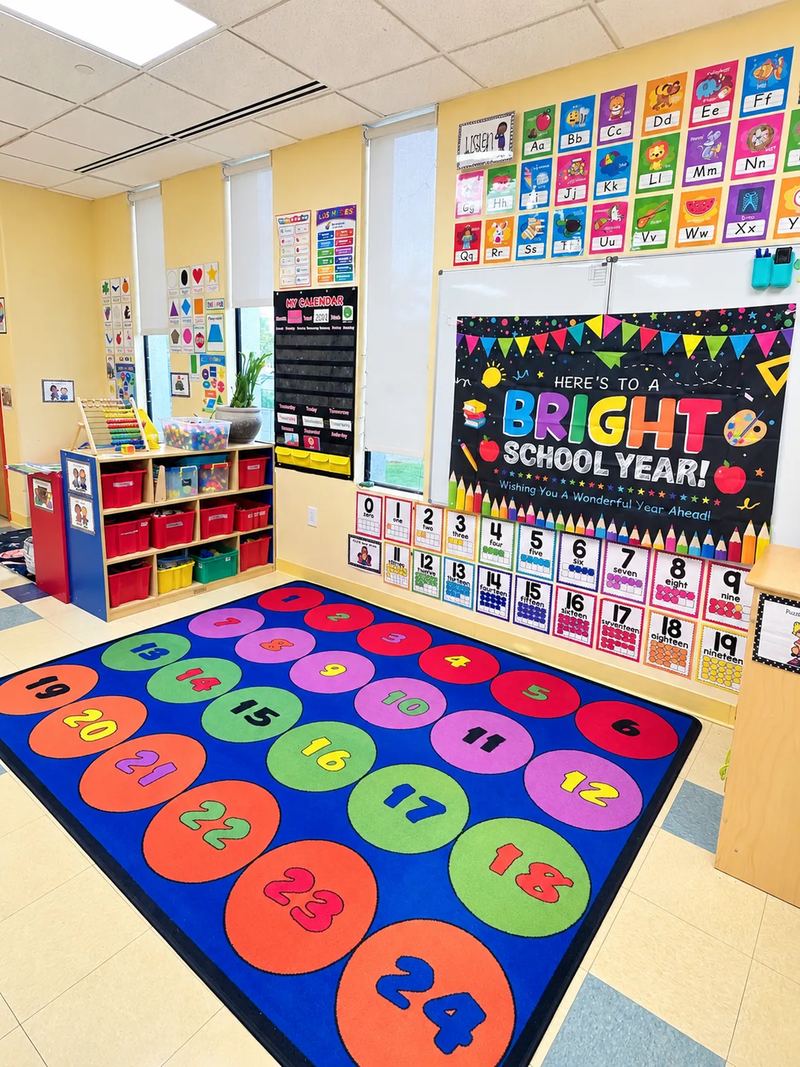 An early learning classroom with an alphabet wall, number cards and a numbered seating rug.